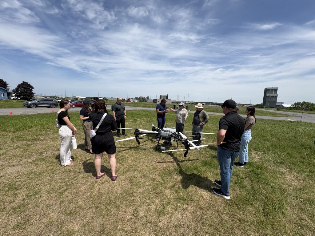 Attendees of the Health Canada meeting at Area X.O examine a drone.